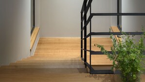 A modern staircase with wooden steps and black metal railings, leading to a landing with a minimalist light fixture. - Median in Vodnjan With 4 Bedrooms and 2 Bathrooms (Vodnjan)