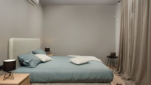 A bedroom with a bed, bedside tables, a nightstand, a lamp, and a curtain. - Median in Vodnjan With 4 Bedrooms and 2 Bathrooms (Vodnjan)