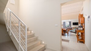 Un interior moderno con una escalera, un comedor y una sala de estar.