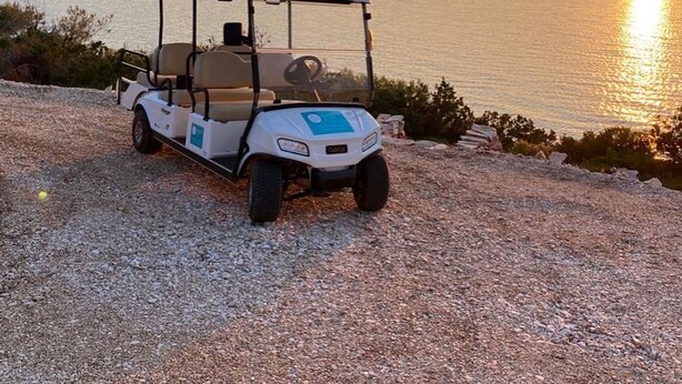 A golf cart parked on a gravel path by a lake at sunset. - Sonia Hvar in Rudina Hvar (Stari Grad)