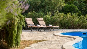 A pool area with two lounge chairs and a stone pathway leading to the pool. - Sonia Hvar in Rudina Hvar (Stari Grad)