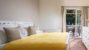 A bedroom with a bed, bedside table, and a view of an outdoor balcony. - Sonia Hvar in Rudina Hvar (Stari Grad)