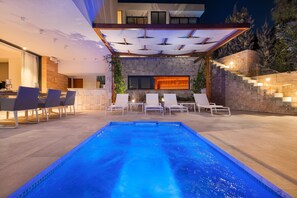 A modern outdoor pool area with a stone wall, lounge chairs, and a bar. - Anabel in Hvar With 4 Bedrooms and 4 Bathrooms (Hvar)