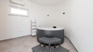 Habitación de esquina con jacuzzi, ventana y perchero.