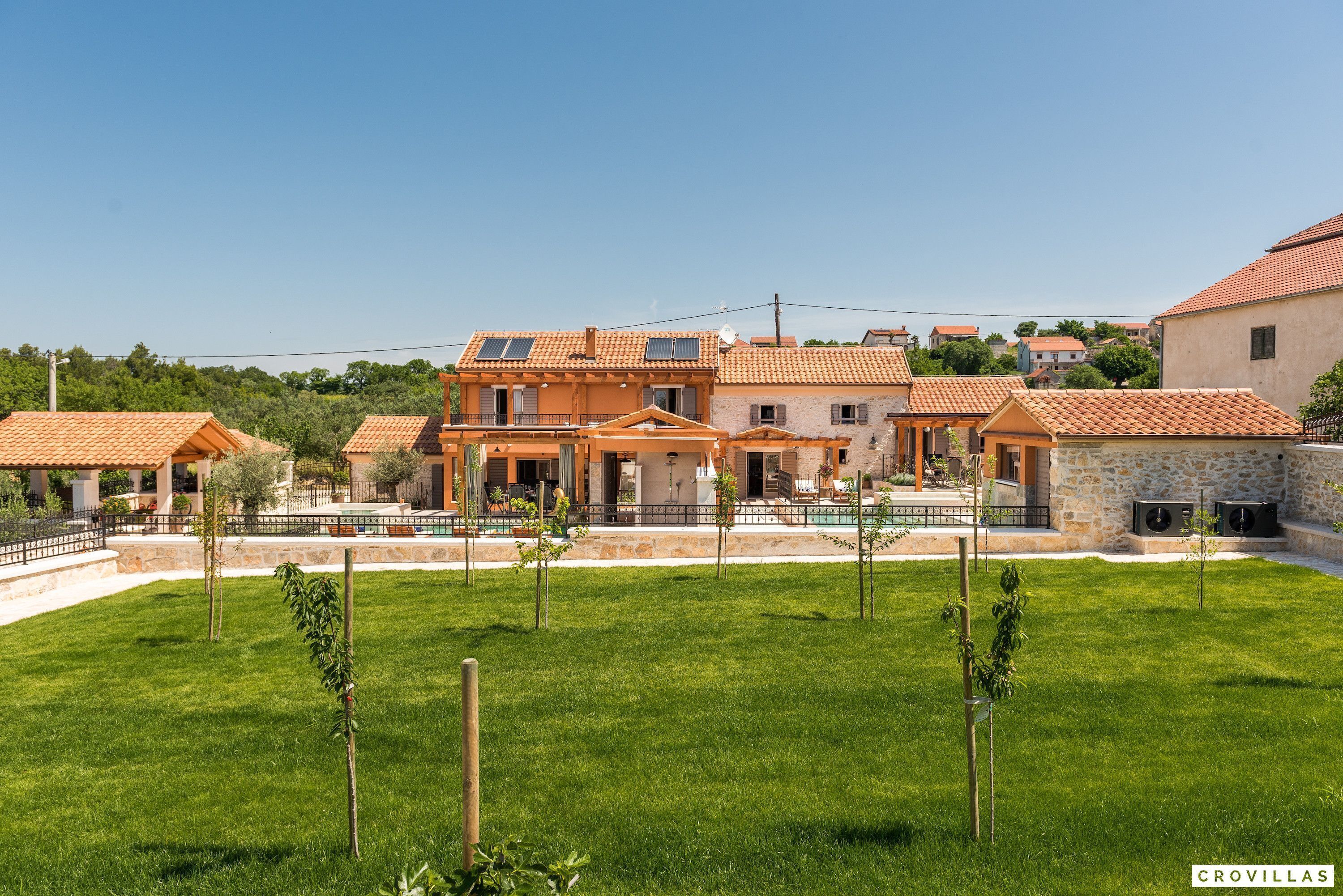 A residential property with a large house, a swimming pool, and a well-maintained lawn.