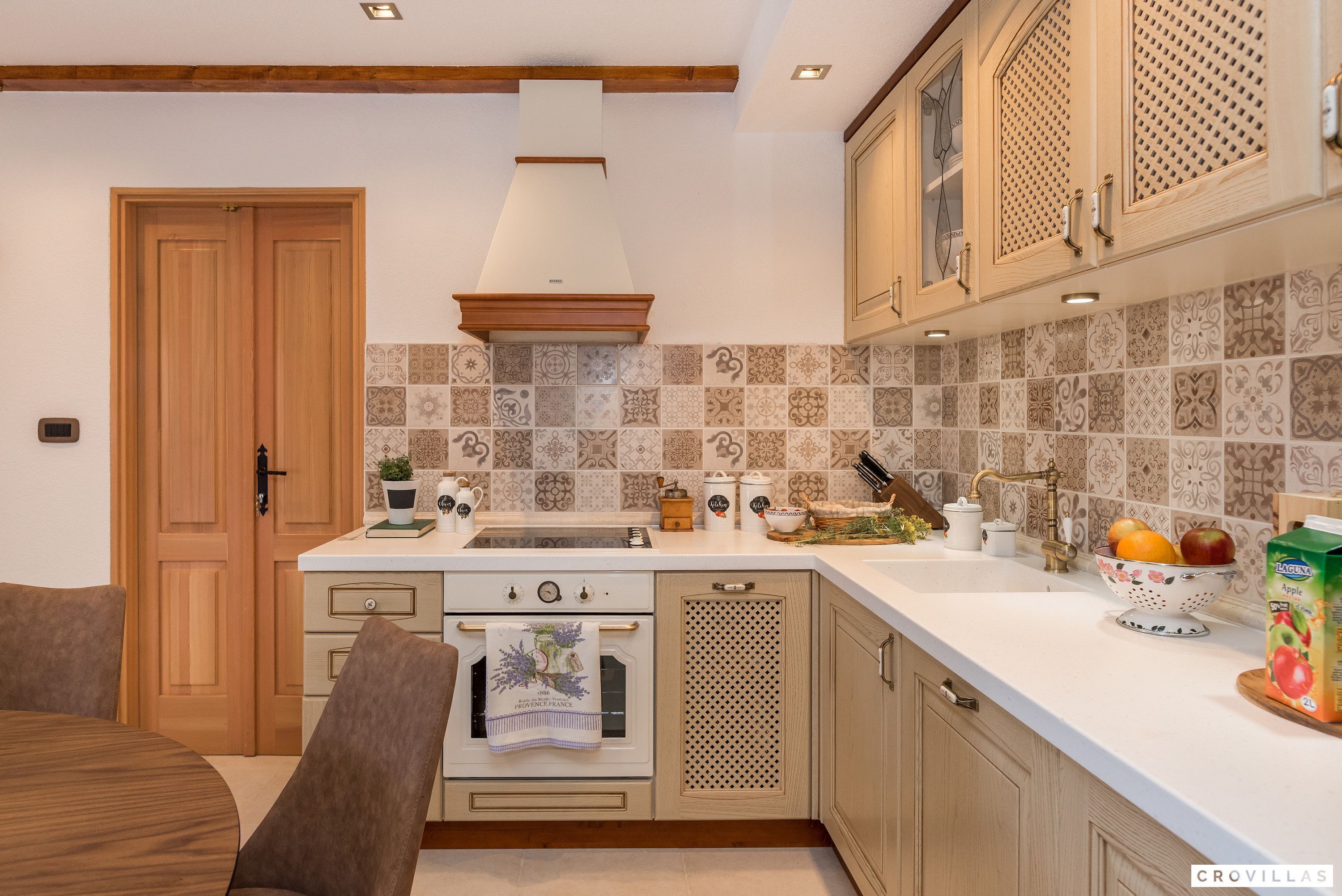 A kitchen with wooden cabinets, a white countertop, and a tiled backsplash.