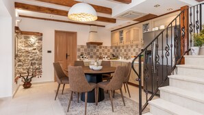 A dining area with a round table, six chairs, and a pendant light. - Ij Dvori in Skradin With 5 Bedrooms and 5 Bathrooms (Skradin)
