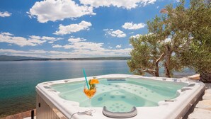 Un jacuzzi con vista despejada a un lago y colinas al fondo.