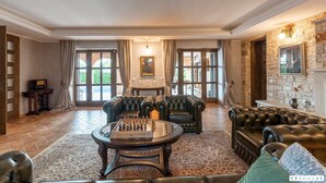 A spacious living room with a chess table, leather sofas, and a fireplace. - Carolus in Barat With 5 Bedrooms and 5 Bathrooms (Visnjan)