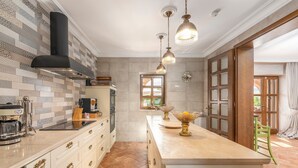 A kitchen with patterned tiles, a central island, and pendant lighting. - Carolus in Barat With 5 Bedrooms and 5 Bathrooms (Visnjan)