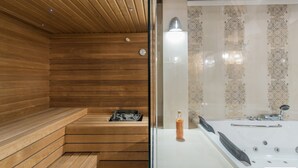 A wooden sauna with benches and a glass partition separating it from a bathroom with a bathtub and a bottle of soap. - Carolus in Barat With 5 Bedrooms and 5 Bathrooms (Visnjan)