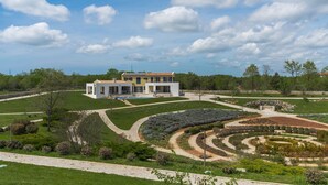 A modern house with a large garden, including a circular lawn and a variety of plants. - Arkaim in Filipana With 5 Bedrooms and 5 Bathrooms (Marcana)