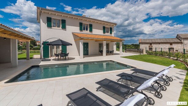 Une maison à deux étages dotée d’une piscine, d’un espace extérieur aménagé et d’un jardin bien entretenu.