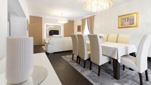 Un espace de salle à manger moderne avec une table blanche, des chaises et un lustre.