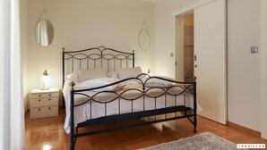 Une chambre à coucher avec un lit, une table de chevet et un miroir.