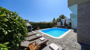 Une piscine avec des chaises longues et une vue sur les montagnes.