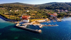An aerial view of a coastal town with a prominent white building, a fortified structure, and a marina with boats. - Muntan in Kraj With 2 Bedrooms and 2 Bathrooms (Pasman)
