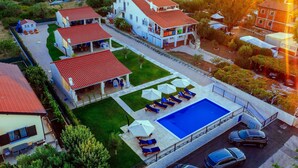 A residential area with a swimming pool, lounge chairs, and a covered patio area. - Muntan in Kraj With 2 Bedrooms and 2 Bathrooms (Pasman)
