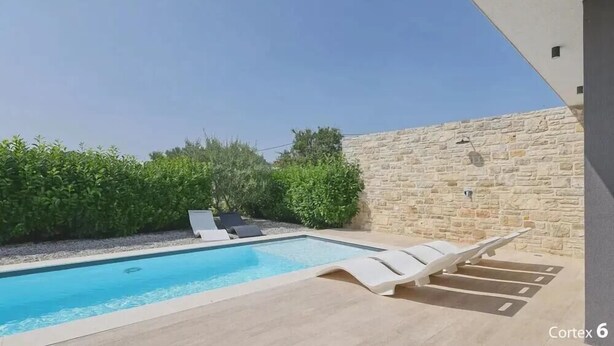 A swimming pool with lounge chairs, surrounded by stone walls and greenery. - K1 in Kraj With 3 Bedrooms and 1 Bathrooms (Pasman)