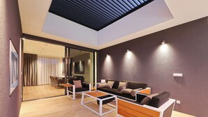 A modern living room with a sofa, coffee table, and chairs. There is a glass door leading to a dining area. - K1 in Kraj With 3 Bedrooms and 1 Bathrooms (Pasman)