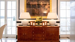 A wooden console table with two lamps, a vase with flowers, and a framed picture above it. - Meys Place in Dubrovnik (Dubrovnik)