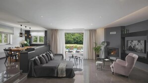 A modern living room with a sofa, a pink armchair, and a dining area with a table and chairs. - Terra Labin in Labin (Labin)