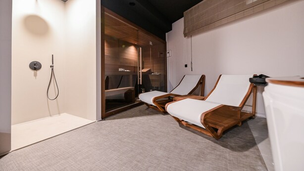 A modern bathroom with a shower, two wooden chairs, and a towel rack. - Vista Hills in Mo Enice (Moscenicka Draga)