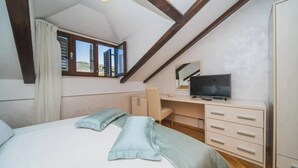 A bedroom with a bed, a desk, a television, and a window with a view. - Franica in Dubrovnik (Dubrovnik)