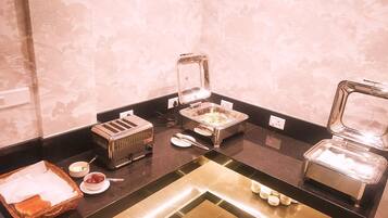 A buffet setup with various food items and appliances.