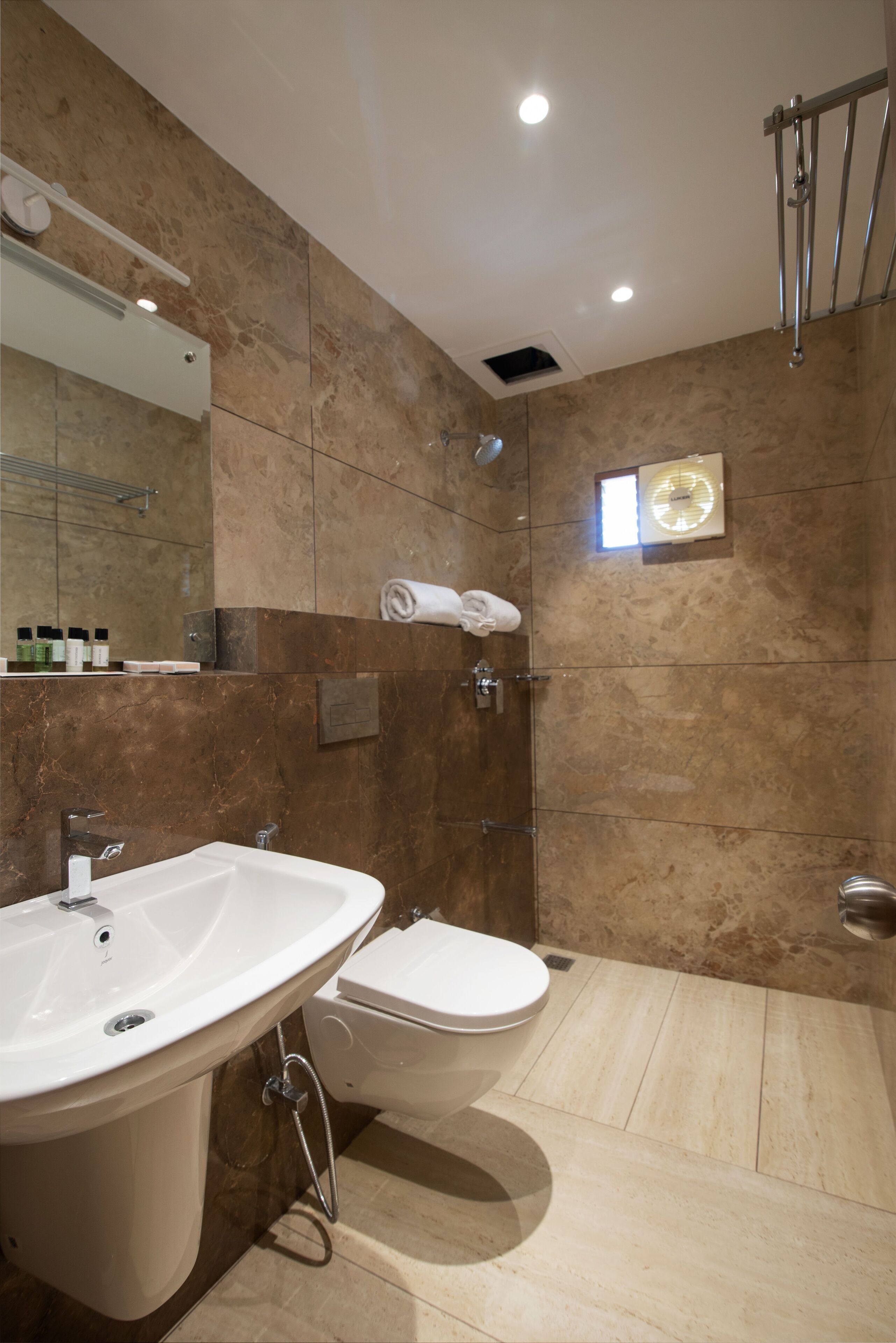 A modern bathroom with a large sink, toilet, and shower area.