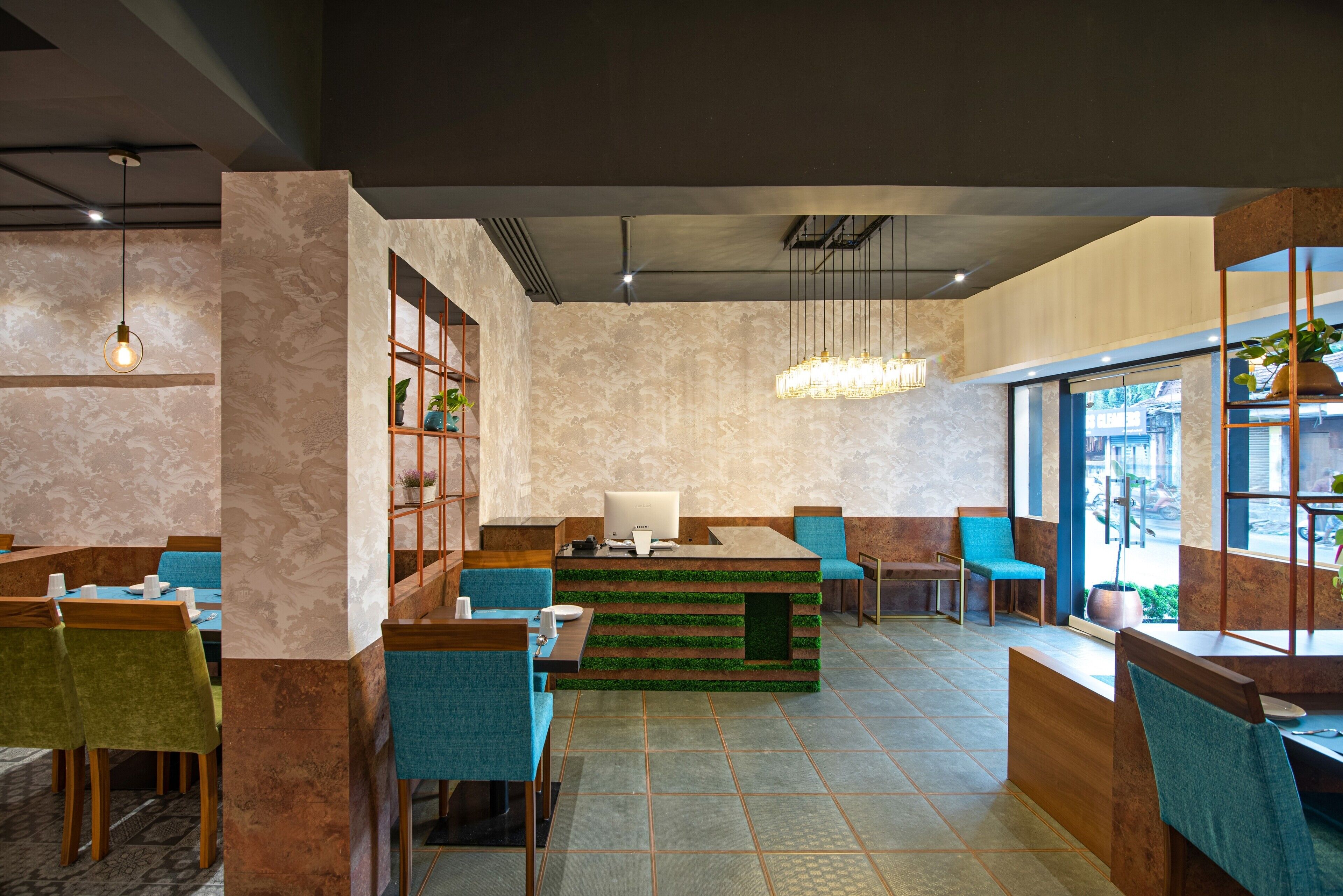 A modern restaurant with a central counter, blue chairs, and a large window.