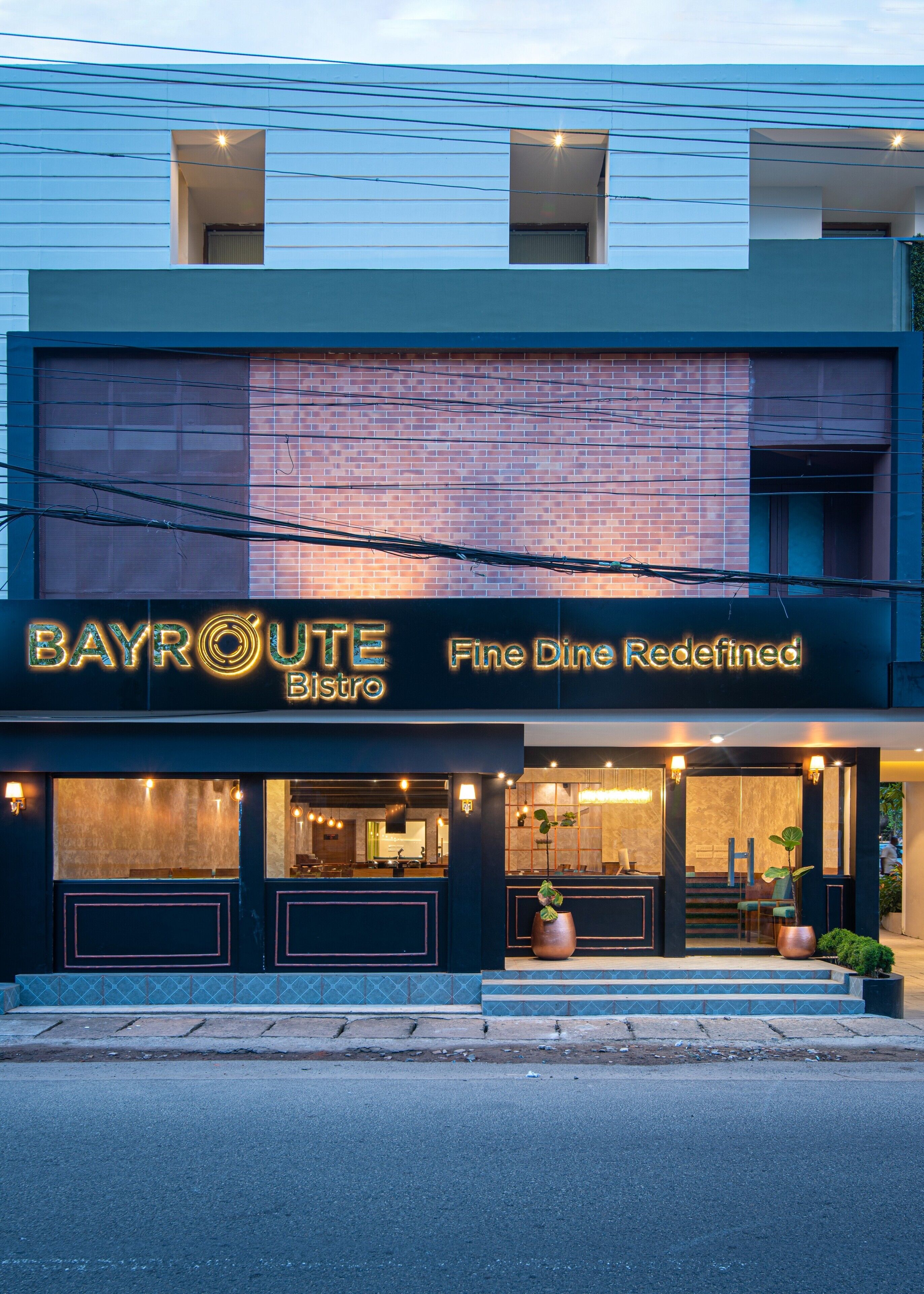 A modern building with a sign reading "BAYROUTE Bistro" and "Fine Dining Redefined".