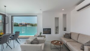 Una sala de estar moderna con un ventanal grande, un comedor y un sofá.