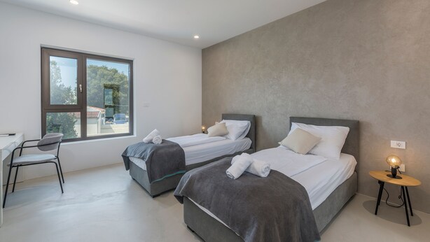 Un dormitorio moderno con dos camas, un escritorio y una silla.