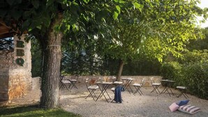 An outdoor seating area with stone walls and trees. - Flavia in Umag With 4 Bedrooms and 3 Bathrooms (Umag)