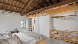 A bedroom with a loft bed, wooden beams, a ladder, a window, and built-in shelves. - Flavia in Umag With 4 Bedrooms and 3 Bathrooms (Umag)