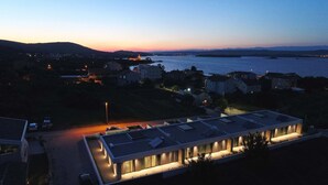 A modern building with a flat roof, large windows, and a parking area. - K2 in Kraj Pa man Island (Pasman)