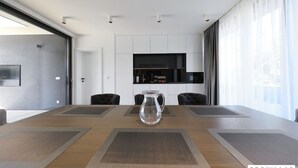 A conference room with a long table, four chairs, a pitcher, and a TV on the wall. - K2 in Kraj Pa man Island (Pasman)