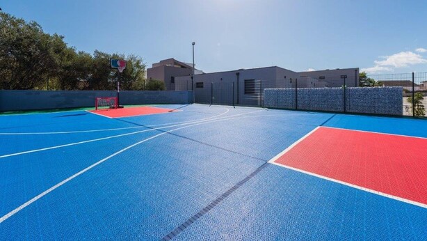 An outdoor basketball court with blue and red surfaces, a basketball hoop, and a fence. - M8 in Vir With 2 Bedrooms and 2 Bathrooms (Vir)