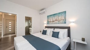 A bedroom with a bed, a painting, and a nightstand. - M8 in Vir With 2 Bedrooms and 2 Bathrooms (Vir)