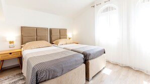 A double room with two beds, each with a headboard, bedside tables, and lamps. - Patria in Ra anj With 4 Bedrooms and 2 Bathrooms (Rogoznica)