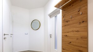 A room with a wooden headboard, a bench, a round mirror, and a door. - Patria in Ra anj With 4 Bedrooms and 2 Bathrooms (Rogoznica)