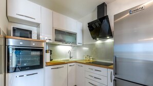 A modern kitchen with white cabinets, a stainless steel refrigerator, a built-in oven, and a microwave. - Patria in Ra anj With 4 Bedrooms and 2 Bathrooms (Rogoznica)