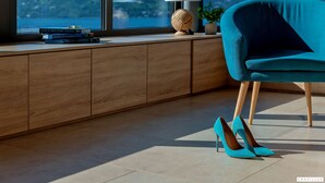 A modern room with a view of a cityscape, a teal chair, a pair of high heels, and a stack of books on a wooden console table. - Soul Stella in Kor ula (Korčula)
