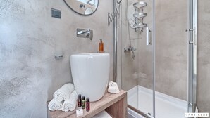 A modern bathroom with a large white sink, a glass-enclosed shower, and a wooden vanity with towels and toiletries. - Treehouse in Murter With 1 Bedrooms and 1 Bathrooms (Tisno)