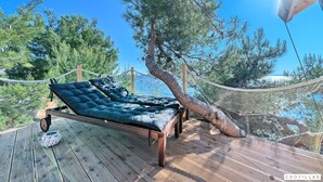 A wooden deck with a bed, a rope barrier, and a view of the sea. - Treehouse in Murter With 1 Bedrooms and 1 Bathrooms (Tisno)
