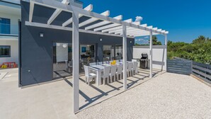 A modern outdoor patio with a pergola, seating area, and a grill. - Luna in Pomer With 6 Bedrooms and 6 Bathrooms (Medulin)
