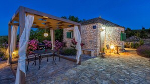 A stone building with a pergola and outdoor seating area. - Magical Island in Mirca (Supetar)