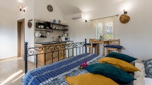 A bedroom with a bed, bedside table, and a view of the kitchen. - Magical Island in Mirca (Supetar)