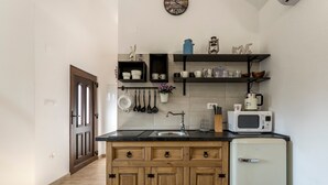 A compact kitchen with wooden cabinets, a white refrigerator, a microwave, and a sink. - Magical Island in Mirca (Supetar)